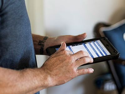 certified home inspector entering inspection details into reporting program on an iPad